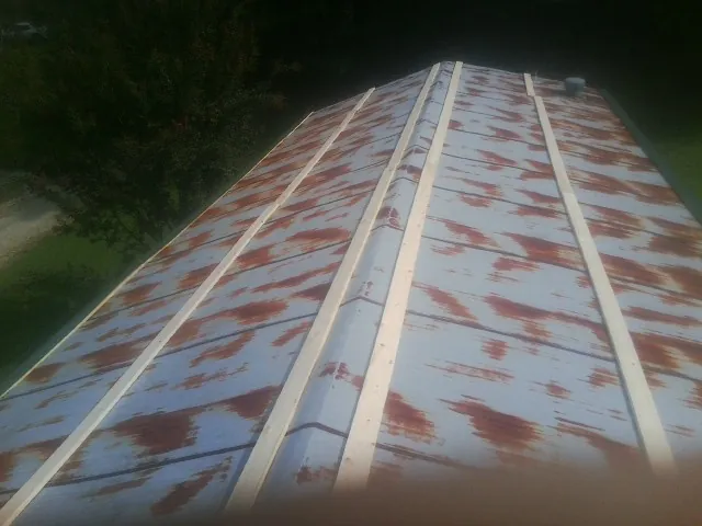 Rusted metal roof panels with new wood purlins before replacement — Storm Damage Roof Repair in Sea Cliff by Roofing Brothers