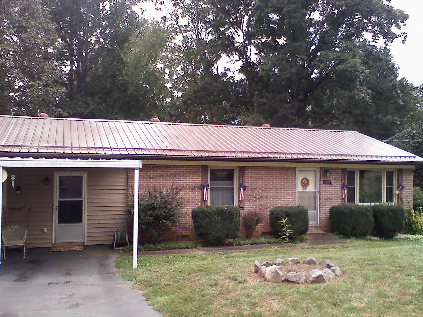 Bronze metal roof and carport on a brick ranch home — Roof Repair work by our crew in Sea Cliff